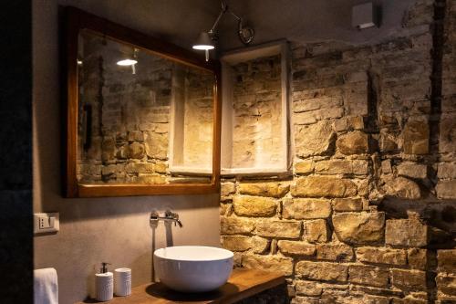 a bathroom with a sink and a stone wall at Tuttaterra in Serra San Quirico