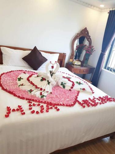 a bed with a heart made out of red pedals at Money Fine Quy Nhơn - Khách sạn dát vàng in Quy Nhon