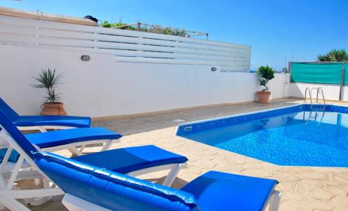 a pool with blue chairs and a swimming pool at Villa Only 50m To The Sea, Sleeps 12, Polis in Pomos
