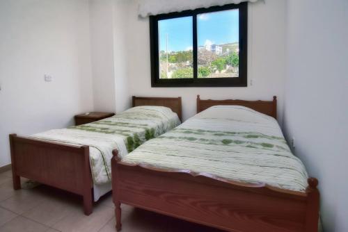 two twin beds in a room with a window at Villa Only 50m To The Sea, Sleeps 12, Polis in Pomos