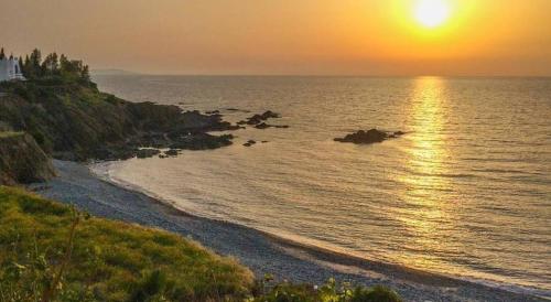 a sunset on a beach with the sun setting over the water at Villa Only 50m To The Sea, Sleeps 12, Polis in Pomos