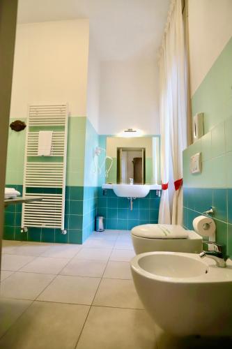 a blue and green bathroom with a sink and a toilet at La Villa del Lago in Ghirla