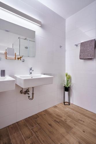 a white bathroom with two sinks and a mirror at Traumvilla auf Krk in Malinska