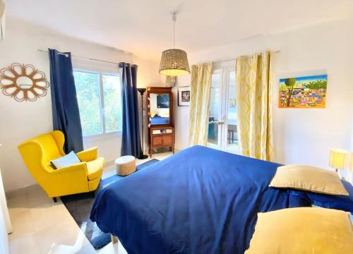 een slaapkamer met een blauw bed en een gele stoel bij VILLA PIERLOU Piscine proche mer pour 6/7 pers in Saint-Raphaël