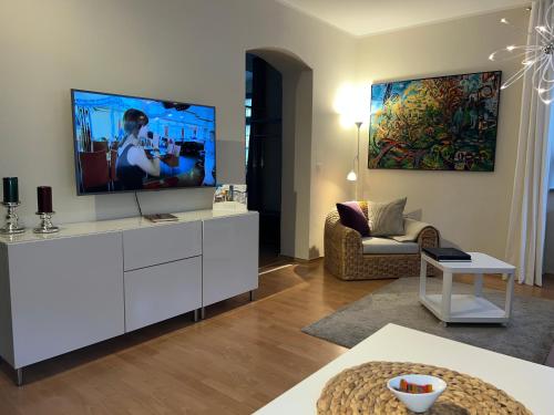 uma sala de estar com uma televisão de ecrã plano num armário branco em Stadthaus Rosengasse em Meissen