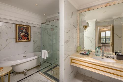 a bathroom with a tub and a sink and a shower at Melia Vinpearl Tay Ninh in Tây Ninh