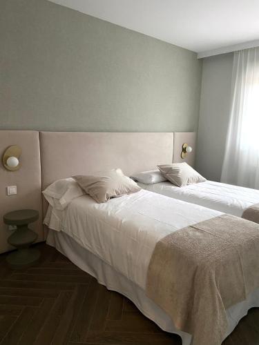 a bedroom with two beds and a window at La casita del Pisueña in La Cueva