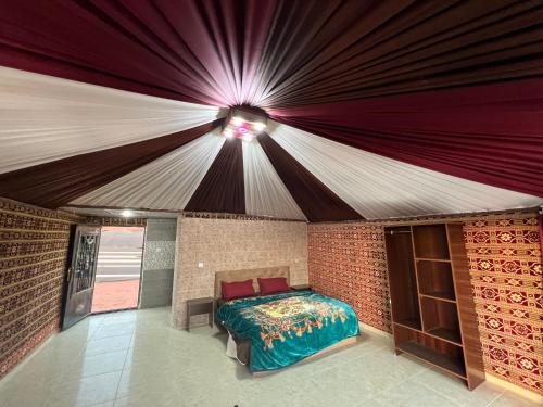 1 dormitorio con 1 cama en una pared de ladrillo en Bedouin candles with tour en Wadi Rum