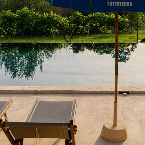 a table and an umbrella next to a body of water at Tuttaterra in Serra San Quirico