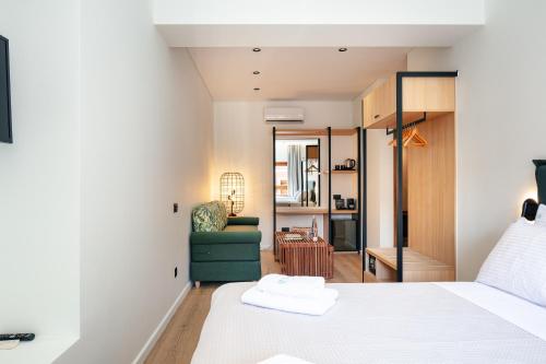 een slaapkamer met een bed en een groene stoel bij Centro Storico in Chania