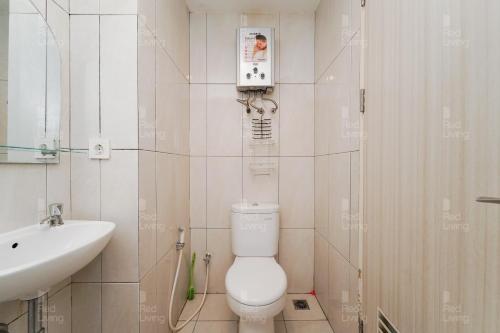 a bathroom with a white toilet and a sink at RedLiving Apartemen Grand Kamala Lagoon - Aoklah Property Tower Barclay North in Bekasi