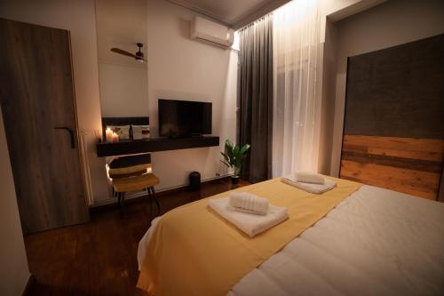 um quarto com uma cama com duas toalhas em URBAN MAISON em Lárissa