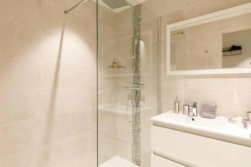 une salle de bain blanche avec une douche et un lavabo dans l'établissement Marriott area superb 1 bedroom, à Cannes