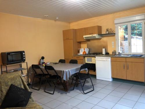 a kitchen with a table and chairs in a kitchen at Gite de la cascade in Les Planches-près-Arbois