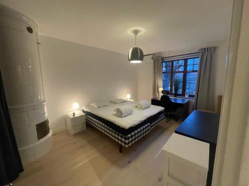1 dormitorio con cama, escritorio y ventana en Topp lägenhet 3a en Estocolmo