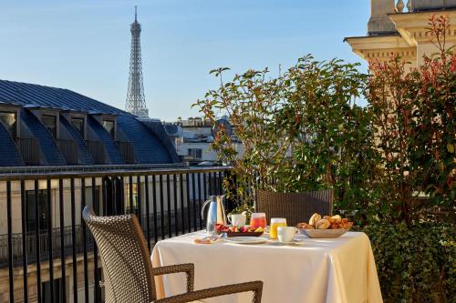 uma mesa com uma tigela de fruta numa varanda em Hôtel Raphael em Paris