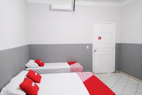 two beds in a room with red and white sheets at OYO Hotel Brás in Sao Paulo