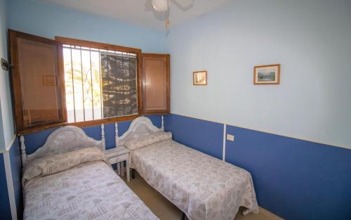 a small room with two beds and a window at Primera línea Playa Romana 17 - ALBERT VILLAS in Alcossebre