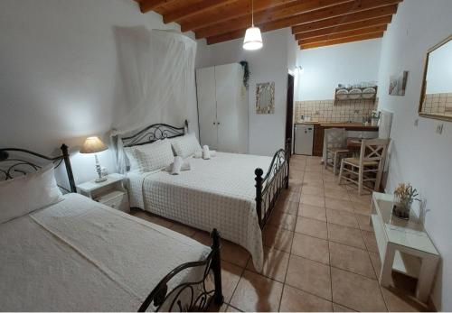 a bedroom with two beds and a table and a kitchen at Stefanos Katsaros Studios in Skala