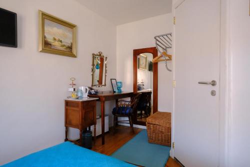 ein Schlafzimmer mit einem Schreibtisch und einem Bett mit einer blauen Decke in der Unterkunft Collier's B&B in Brügge