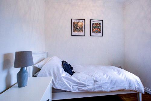 a bedroom with a bed and three pictures on the wall at Beautiful 2 bedroom Apartment, Romford in Romford