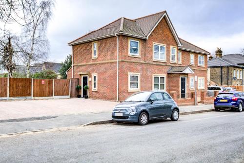 a car parked in front of a brick house at Beautiful 2 bedroom Apartment, Romford in Romford