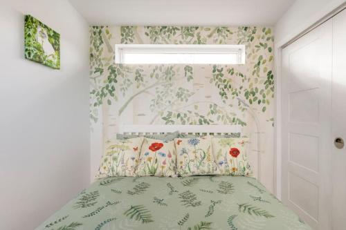 a bedroom with a bed with flowers on the wall at Cosy and modern 1 bedroom garden house - very dog friendly! in Tarves