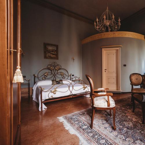 a bedroom with a white bed and a chair at Salotto delle Arti in Modena