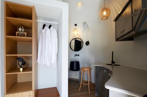 a room with a closet with a white robe on it at Aecon Suites in Éxo Goniá