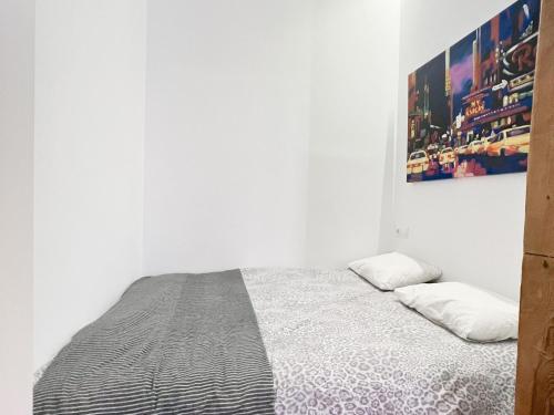 a bedroom with a bed with a picture on the wall at El Tesoro de Malasaña in Madrid