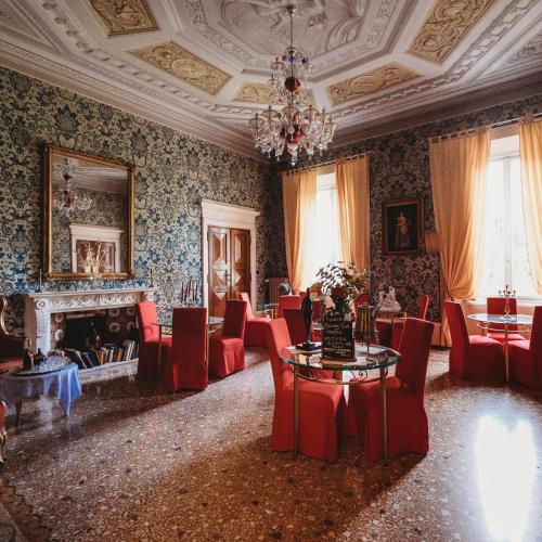 um quarto com cadeiras, uma mesa e uma lareira em Salotto delle Arti em Modena