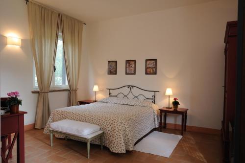 1 dormitorio con 1 cama, 2 mesas y una ventana en Agriturismo Tenuta Conti Faina, en Fratta Todina