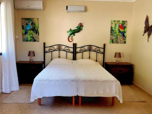 1 dormitorio con 1 cama y 2 cuadros en la pared en Casa Granero, en Frigiliana