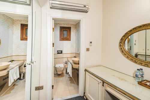 Un baño con lavabo, inodoro y espejo. en Hotel Fresia Istanbul, en Estambul