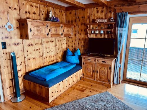 Zimmer mit Sofa und TV in einer Hütte in der Unterkunft Musi Appartements in Schönberg im Stubaital
