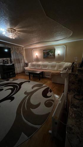 a living room with a couch and a rug at Просторі та комфортні апартаменти «Д.І.М.» in Kamianets-Podilskyi