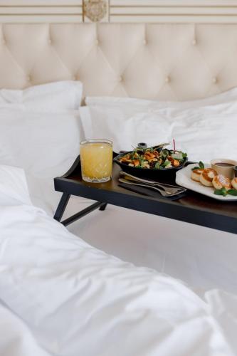 a tray of food and drinks on a table on a bed at Chevalier Hotel & SPA in Bukovel