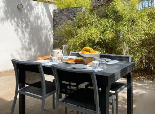 un tavolo nero con un cesto di frutta sopra di Appartement Océane - Villas Lake and Sea a Seignosse