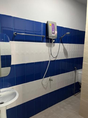 a bathroom with a blue and white tiled wall at Reggaeinn in Phi Phi Islands