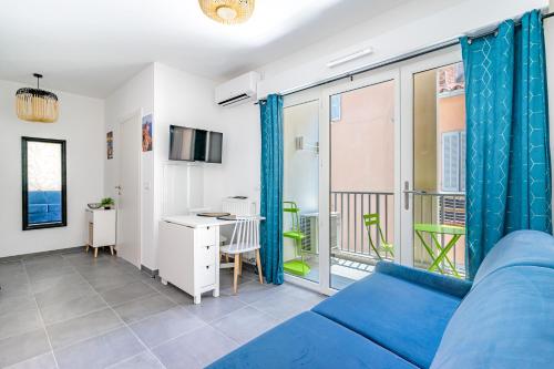 un salon avec un canapé bleu et un balcon dans l'établissement LA CIOTAT - Magnifique Studio Cigale au pied du Port-Vieux, à La Ciotat