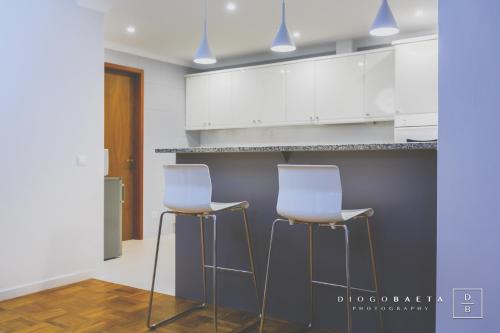 two white stools in a kitchen with white cabinets at This is Heaven in Funchal in Funchal