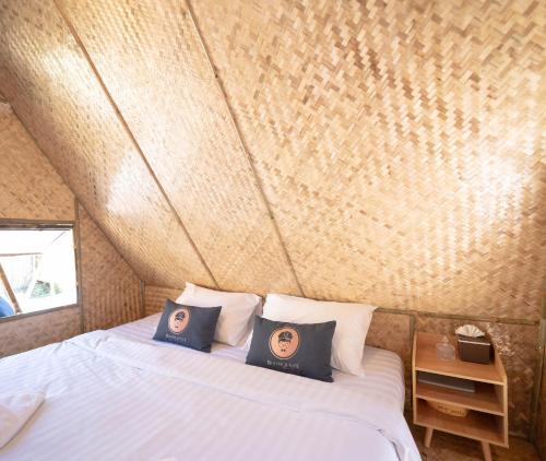 a bed with two pillows on it in a room at Yellowstone Camps Resort Sapan in Ban Huai Ti