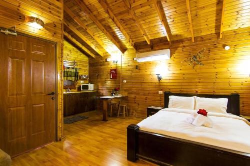 a bedroom with a bed and a wooden wall at Keren Or in Netiv HaShayyara