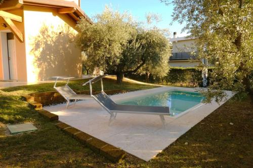 two chairs sitting next to a swimming pool at Villa Lidia - tra il verde e l’azzurro. in San Felice del Benaco