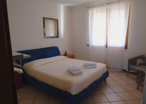 a bedroom with a bed with two towels on it at Villa Lidia - tra il verde e l’azzurro. in San Felice del Benaco