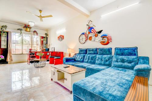 a living room with a blue couch and a table at FabHotel Corporate Residency in Pune