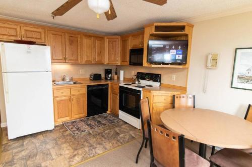 a kitchen with a table and a white refrigerator at ML229 Mountain Escape! Great for relaxing! 2BR 2BA in Snowshoe