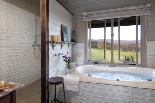 a bath tub in a bathroom with a window at Fellcroft Farmstay in Cobaw