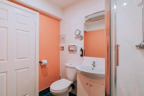a bathroom with a toilet and a sink at Malacuna Liverpool in Liverpool