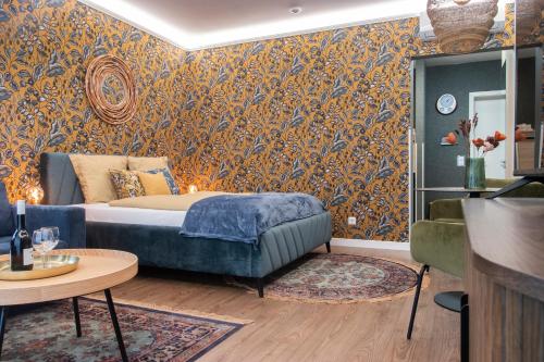 a bedroom with a bed and a wall covered in wallpaper at Grand Suites Corvin in Budapest
